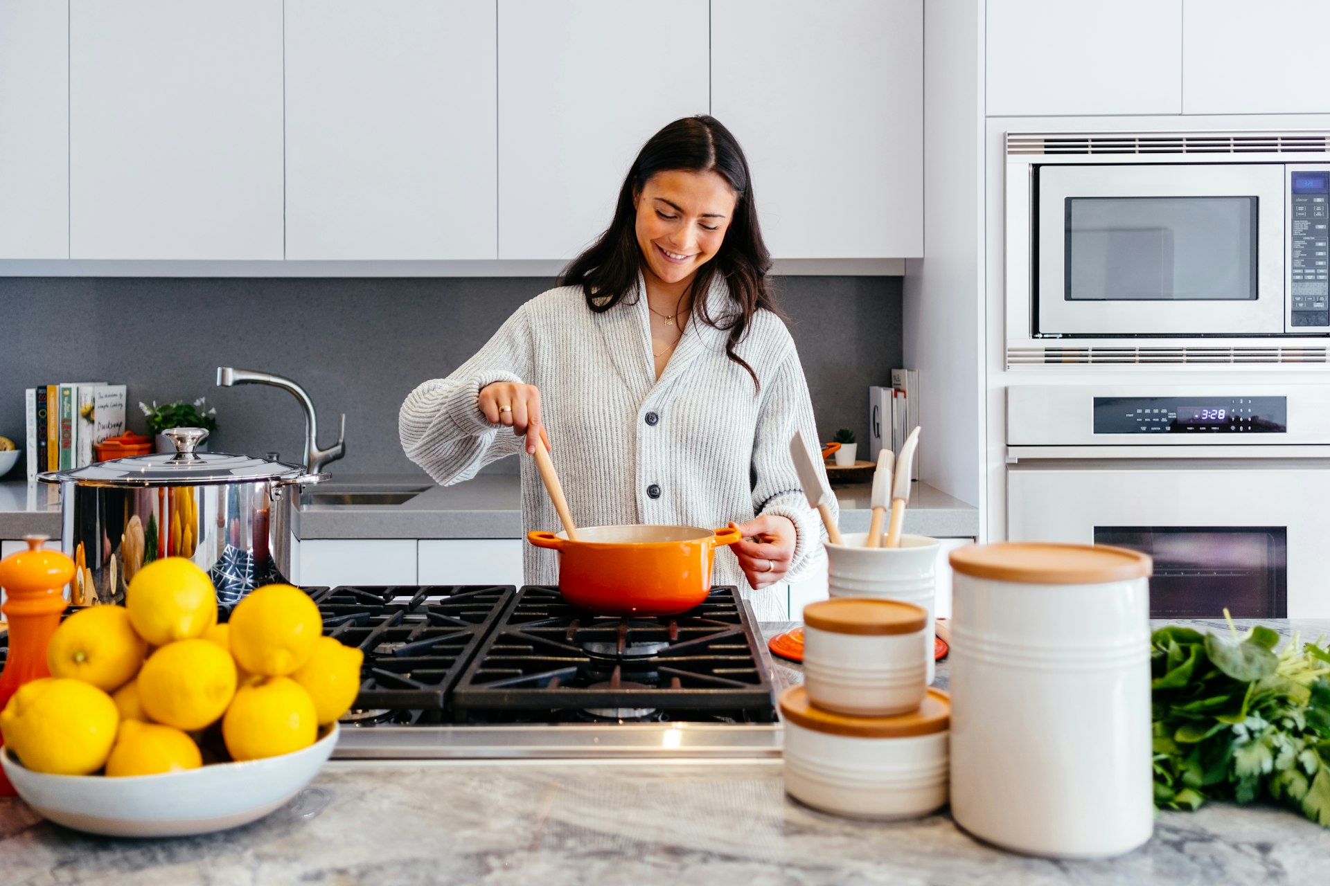 Happy customer cooking in a modern kitchen fitted by Arya Kitchen Appliances